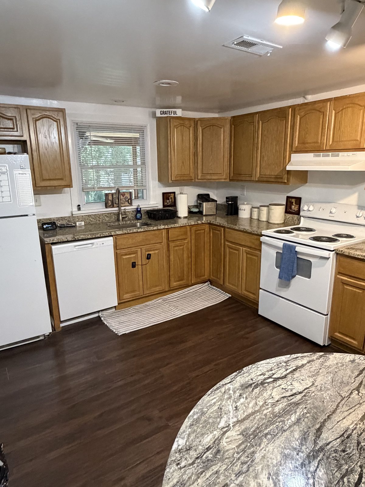 Home kitchen with wood cabinets, granite counters and a bright window