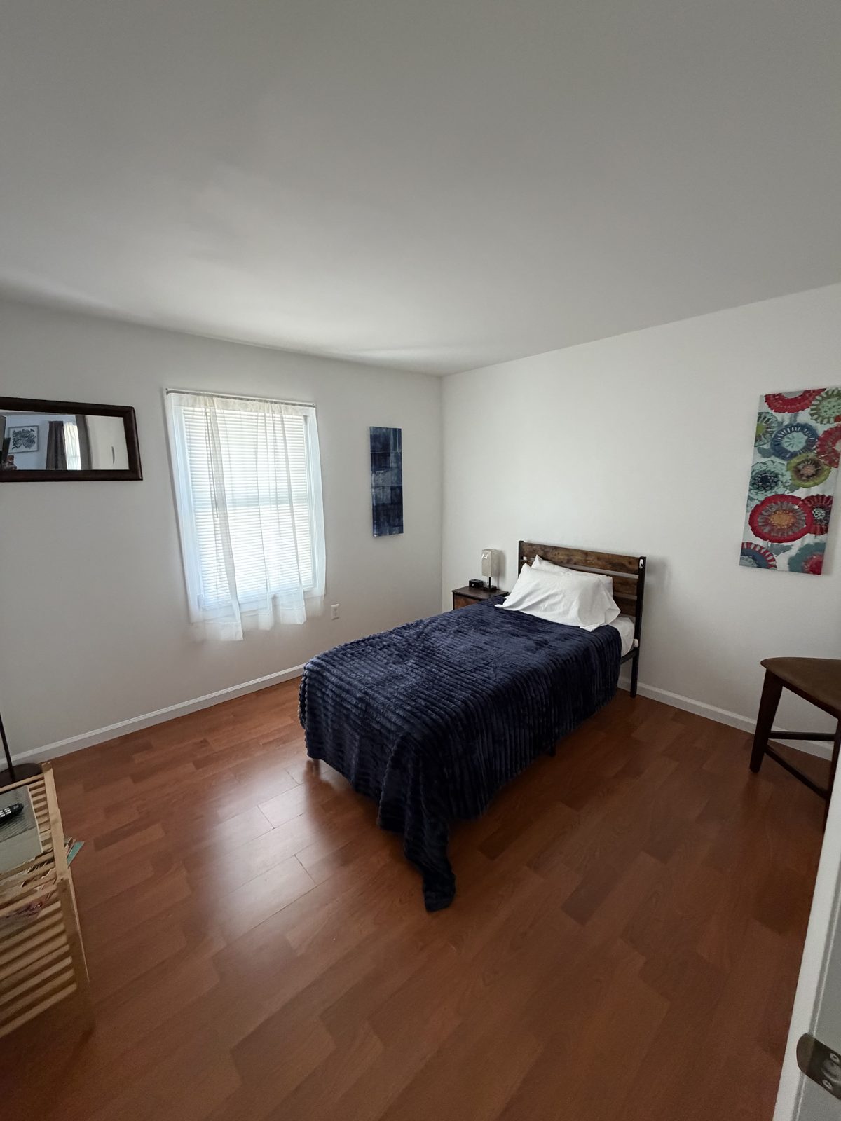 Comfortable bedroom with soft bedding, artwork and natural light